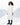 A woman standing in a long white winter coat with a snowy background