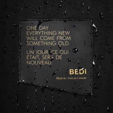 A close up of the raincoat's waterproof material, with a rubber patch with the bedi slogan