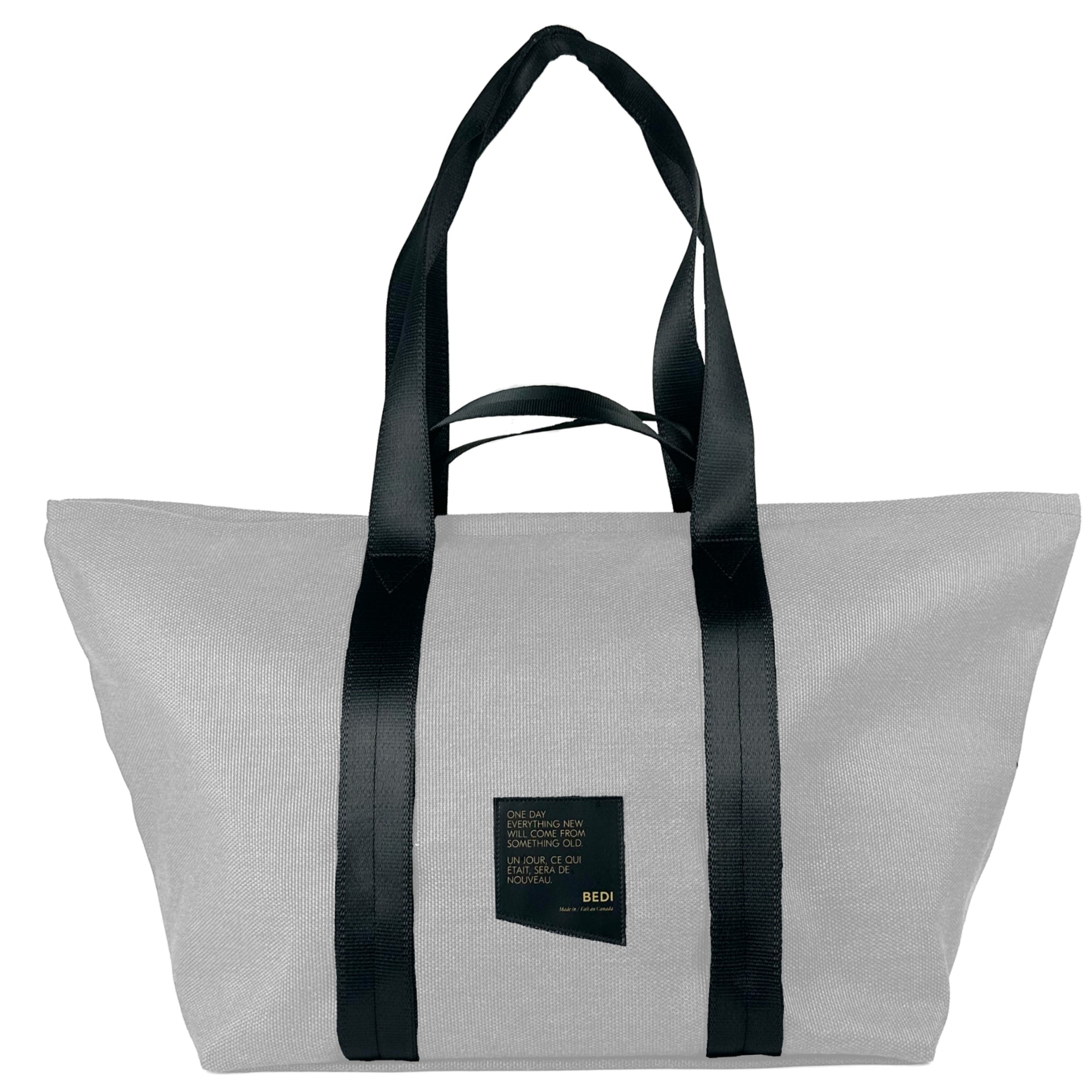 front view of a duffle bag in white twill material, against a white background.