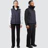 A man and a woman stand, each wearing a unisex navy blue vest