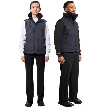 A man and a woman stand, each wearing a unisex navy blue vest