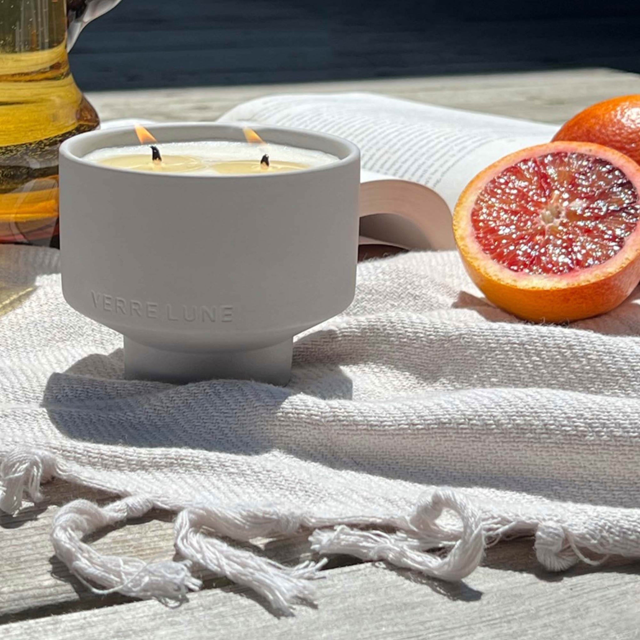 The grove candle in a relaxing environment. grapefruits, lifestyle picture.