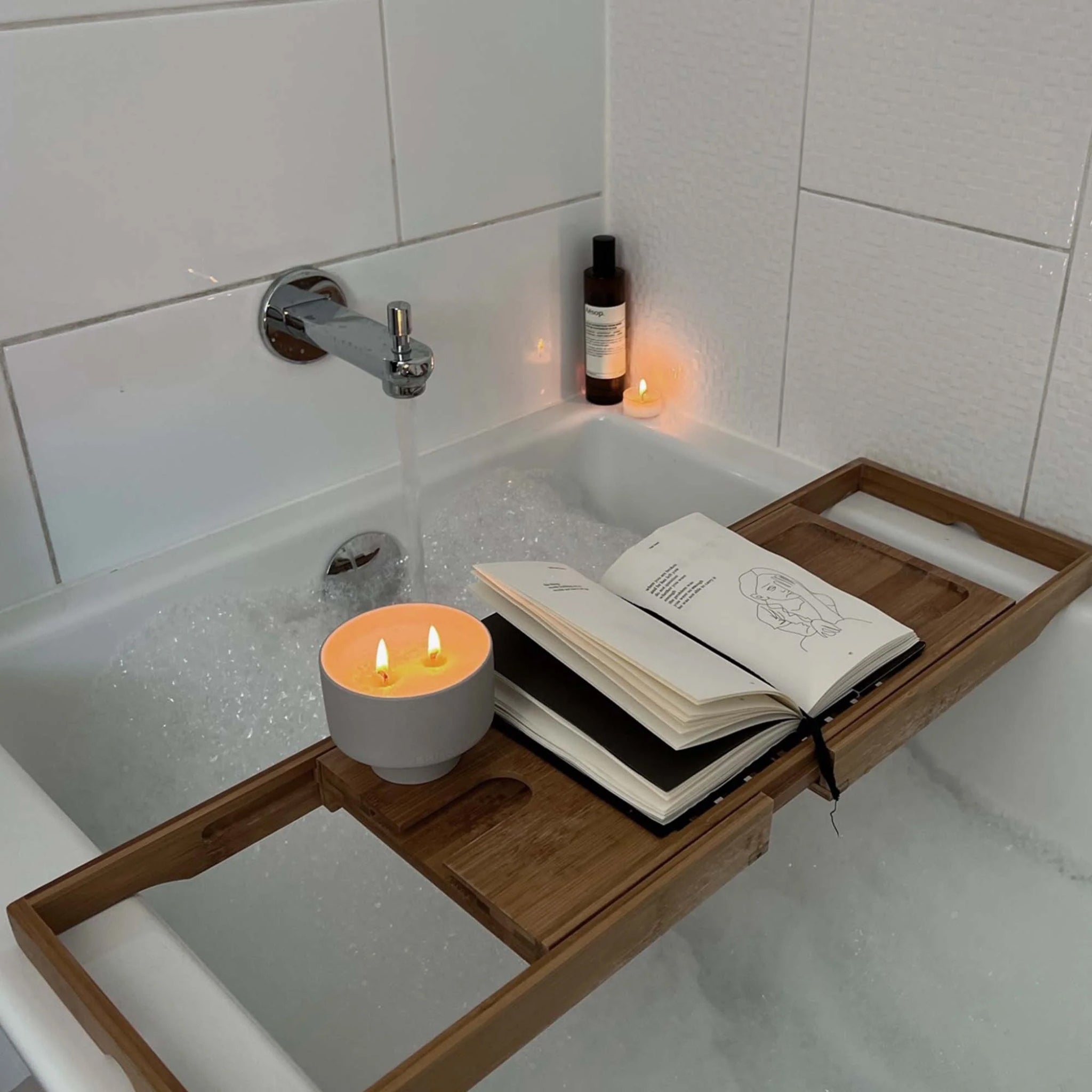 Verre Lune stone candle lit in a dimmed and relaxing bath setting 