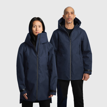 Two people wearing matching navy blue raincoats on a light grey background