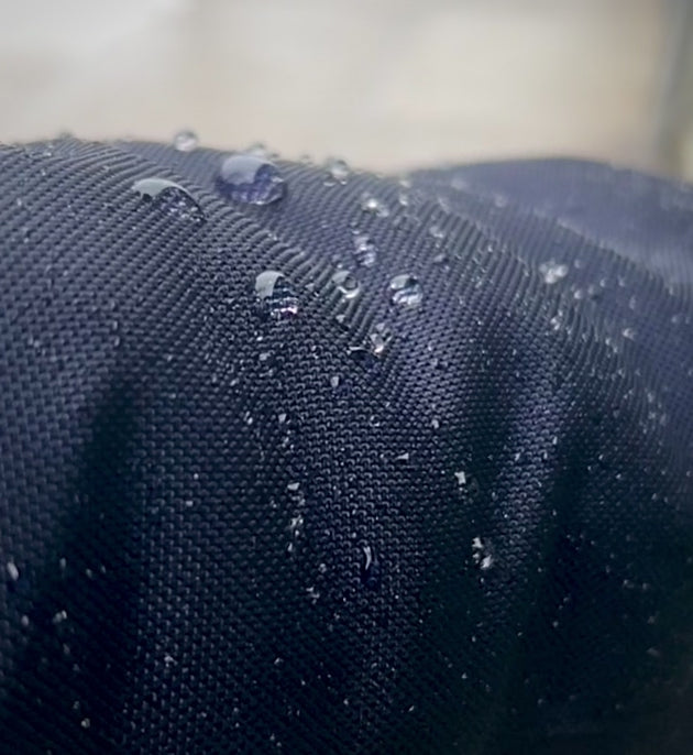 Raindrops roll off the Econyl material on the sleeve of a Bedi winter coat