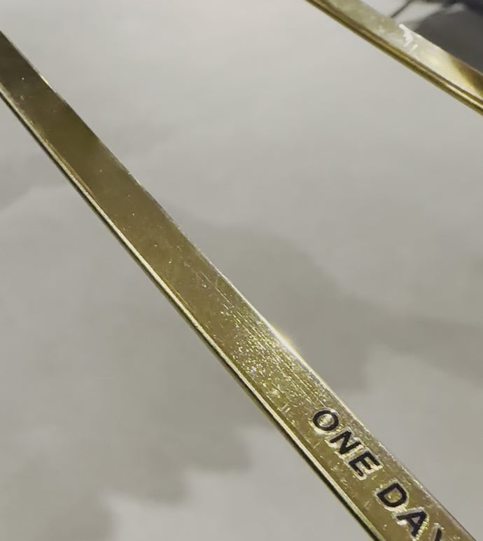 A slow pan over the interior of a brass hanger, with the Bedi slogan embossed.
