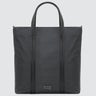 A large minimalist tote bag in grey nylon material, with a black strap that runs the height of the bag