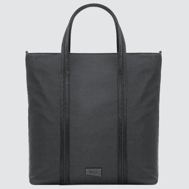 A large minimalist tote bag in grey nylon material, with a black strap that runs the height of the bag