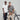 a man and a woman, both wearing cotton Sam tshirts, leaning against a bike in front of a plain grey background