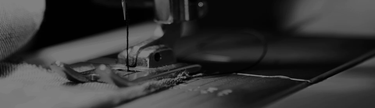 A close-up of a sewing machine stitching a hem