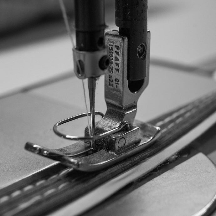 A close up of the sewing needle on a sewing machine