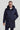 Man wearing a navy blue coat with a hood on a light gray background