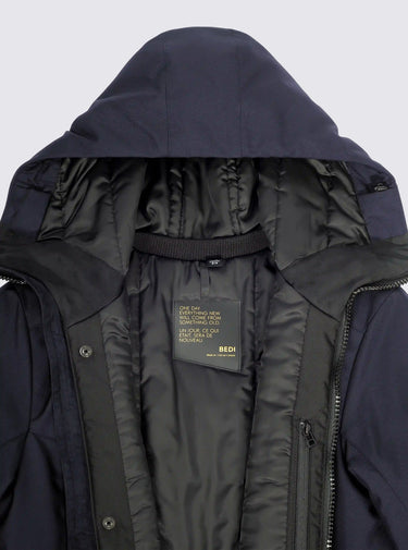 Close-up of a dark blue hooded jacket with a brand label on a white background