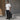 Man holding a black tote bag against a modern building background