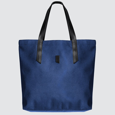 Blue tote bag with black handles on a light gray background