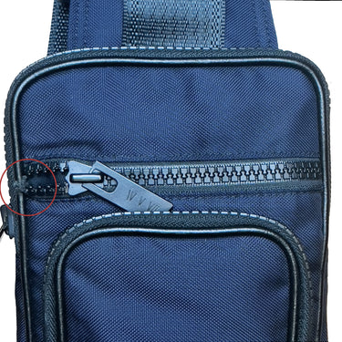 Close-up of a blue bag with a zipper, showing wear and tear.