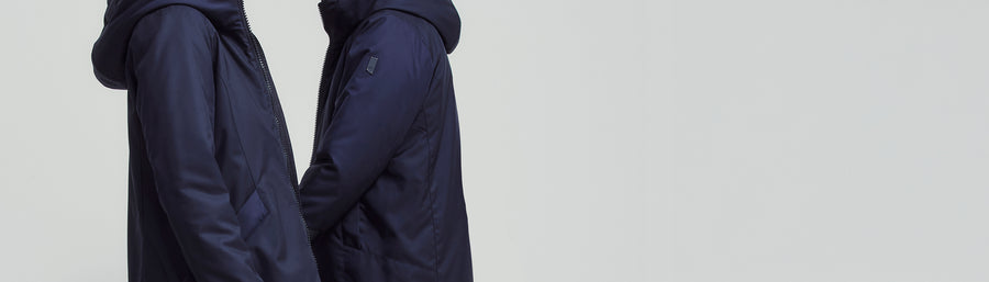 two models in navy winter coats walking toward each other